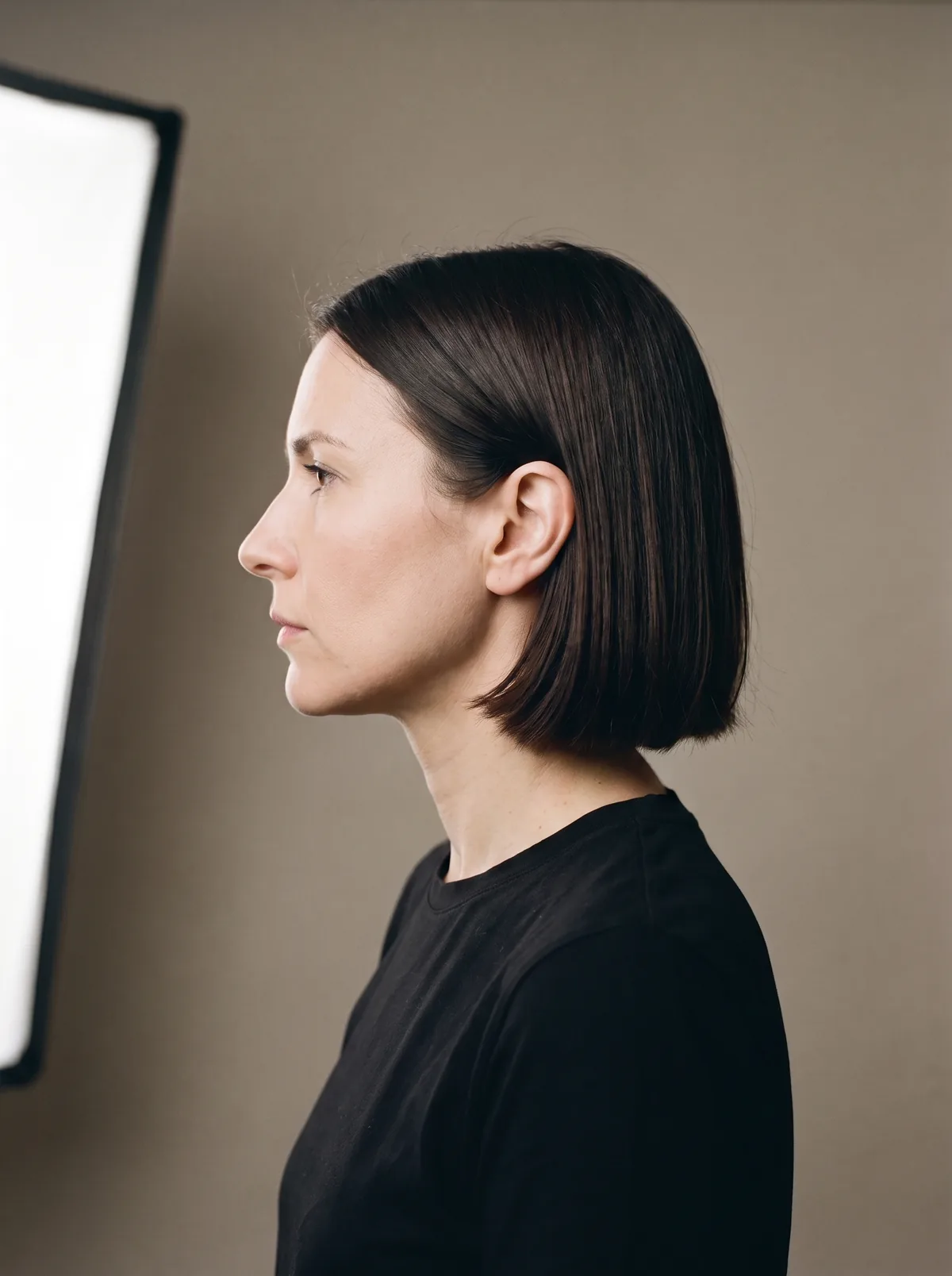 Dieselbe Frau im Profil, die Kante des Bobs läuft gerade auf Kinnhöhe aus.