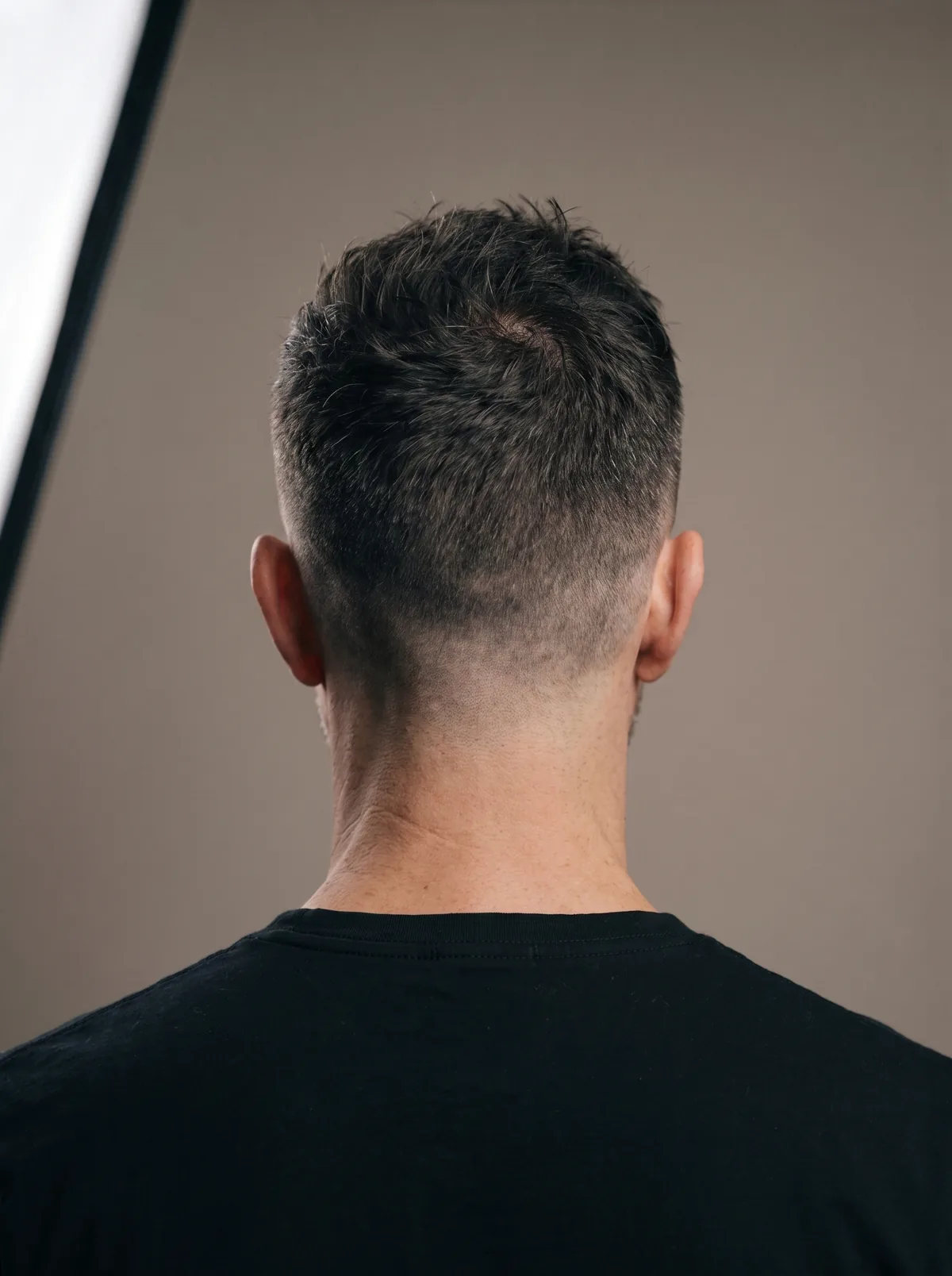 Derselbe Mann von hinten, der Nacken ist kurz ausgeschnitten und offen.
