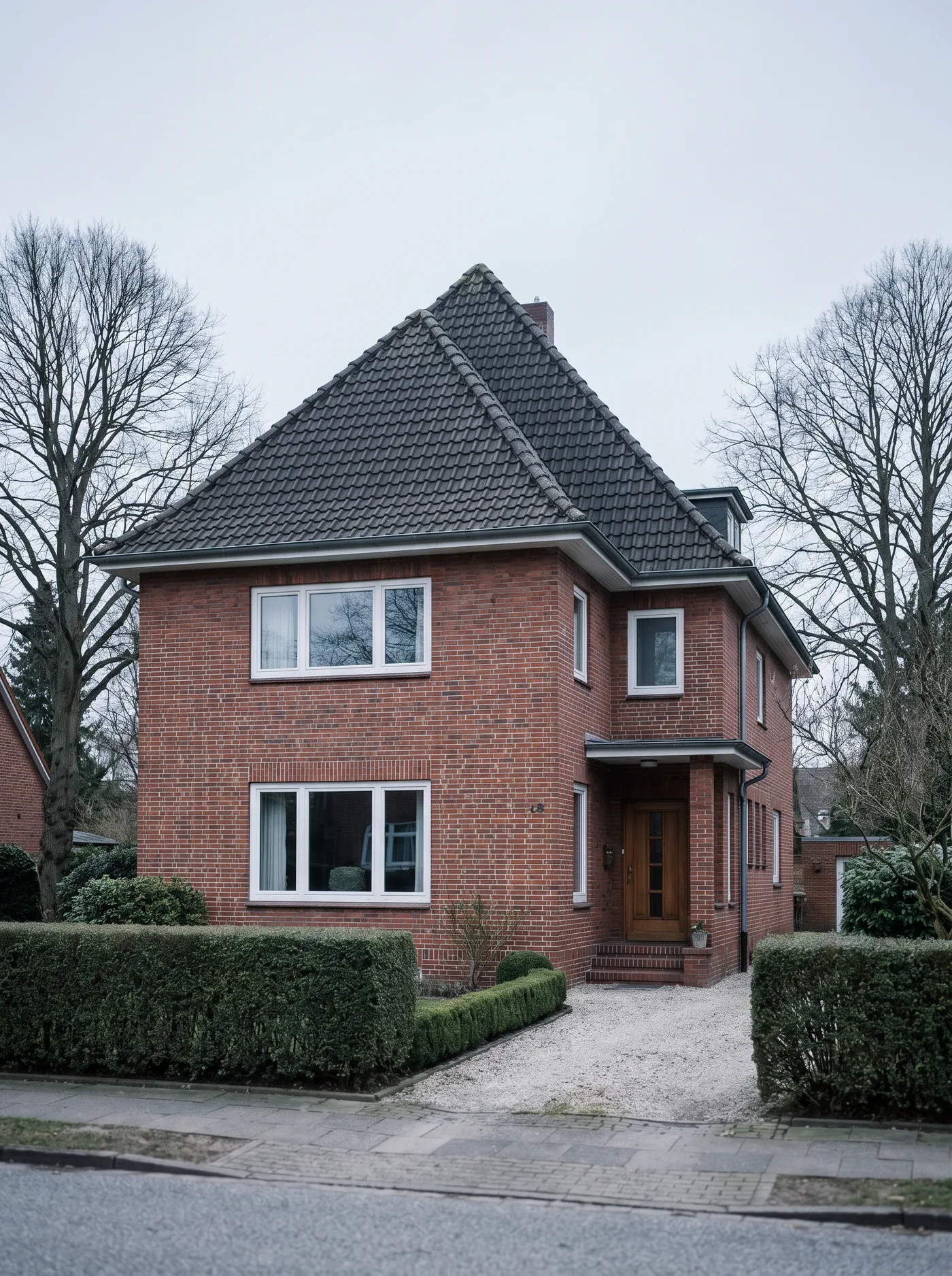 Landhaus in Othmarschen hinter einer Hecke.